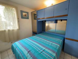 Schlafzimmer mit einem Bett mit blauen Wänden und einem Fenster in der Unterkunft Maison Saint-Cyprien, 2 pièces, 6 personnes - FR-1-225D-161 in Saint-Cyprien