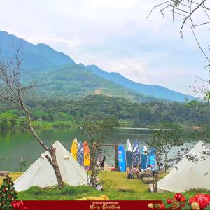 a group of tents on the grass near a lake at Đào Hoa Glamping in Hanoi