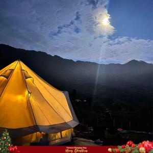 a yellow tent with the moon in the background at Đào Hoa Glamping in Hanoi