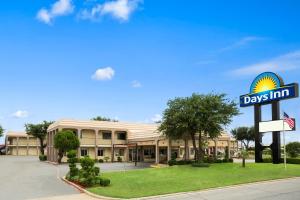 un panneau d'auberge devant un bâtiment dans l'établissement Days Inn by Wyndham Dallas Irving, à Irving