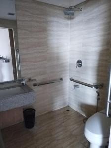 een badkamer met een douche, een toilet en een wastafel bij Relaxing Big Studio Bedroom in Manilla