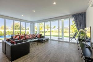 Elle comprend un salon doté de meubles et d'une grande fenêtre. dans l'établissement Modern 3 bedroom Pool Villa PG19, à Cha Am