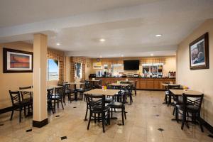 a kitchen with a table, chairs, and a refrigerator at Days Inn by Wyndham Dallas Irving in Irving