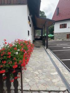 a building with a bunch of flowers on the sidewalk at Rooms Imperial House in Plitvička Jezera