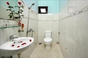 La salle de bains blanche est pourvue d'un lavabo et de toilettes. dans l'établissement Dong Nguyen Riverside Homestay, à Hội An