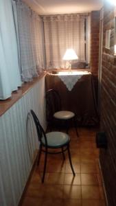 Habitación con 2 sillas, mesa y lámpara en ATENAS 18 LA PERLA (BALN. ALFONSINA) en Mar del Plata