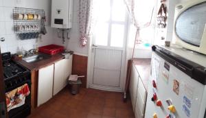 una pequeña cocina con fregadero y nevera. en ATENAS 18 LA PERLA (BALN. ALFONSINA) en Mar del Plata