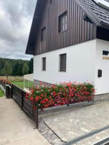 a building with flowers on the side of it at Rooms Imperial House in Plitvička Jezera