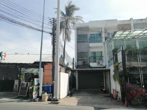 a building with a garage and a palm tree at Baan7984 Rawai in Rawai Beach