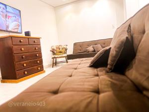 - une chambre avec un canapé, une commode et une télévision dans l'établissement Apartamento frente mar c/ar P/ 6 hóspedes, à São Vicente