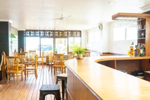 プルカンにあるArton Resort & Beach Clubの木製のテーブルと椅子のあるバー付きのレストラン