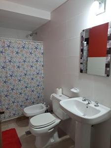 a bathroom with a toilet and a sink at MODERNO DUPLEX Con COCHERA in Luzuriaga