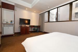 1 dormitorio con 1 cama y TV de pantalla plana en Shanger Hotel en Taipéi