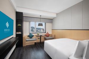 a hotel room with a bed and a desk at Xin'an Yihao Hotel - Near Xiamen Railway Station, near Vientiane City, minibar is free in Xiamen