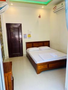 1 dormitorio con 2 camas y puerta en Aloha Hotel, en Phan Rang