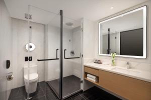 a bathroom with a shower and a toilet and a sink at Xin'an Yihao Hotel - Near Xiamen Railway Station, near Vientiane City, minibar is free in Xiamen