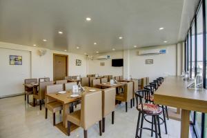 a dining room with wooden tables and chairs at Treebo Trend Grand Gurugram in Gurgaon