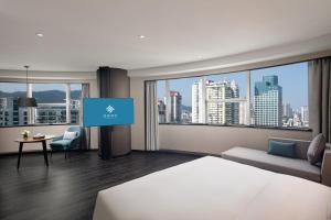 a hotel room with a bed and a tv at Xin'an Yihao Hotel - Near Xiamen Railway Station, near Vientiane City, minibar is free in Xiamen