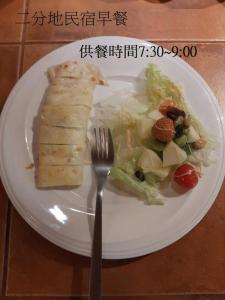 a white plate with a piece of food and a fork at Erfen De Homestay in Guanshan