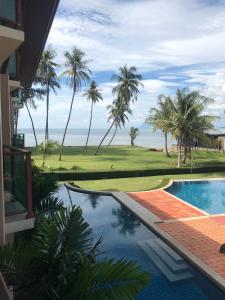 - une piscine avec vue sur un parcours de golf dans l'établissement LANTA PURA beach resort-SHA extra plus, à Ko Lanta
