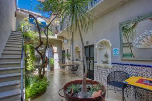einen Innenhof mit einem Tisch, Stühlen und Pflanzen in der Unterkunft La Mexicana Hotel Boutique in San Miguel de Allende
