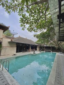 uma grande piscina azul numa casa em chrome hotel & resort solo em Tjolomadu