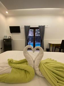 a bed with two swans making a heart at chrome hotel & resort solo in Tjolomadu
