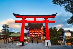 a red torii gate in front of a building at One More Heart Fushimi Inari in Momoyama-chō
