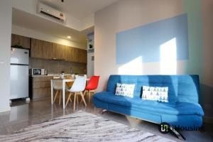 uma sala de estar com um sofá azul e uma cozinha em Imperio Residence Melaka By I Housing em Malaca