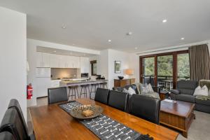 a living room with a couch and a table at Elevation 2 bedroom with guest room gas fire and mountain views in Thredbo
