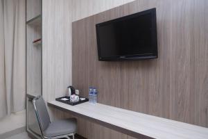 a television on a wall in a hotel room at Sans Hotel Lynt Makassar in Makassar