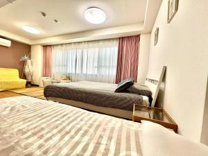 una camera da letto con due letti e una finestra di 難波無印ノ家 ad Osaka