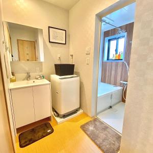 une salle de bain avec un lavabo, des toilettes et une douche dans l'établissement Guest House One More Heart at Kyoto Station South 5, à Kyoto