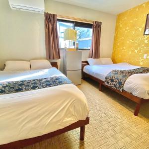 une chambre d'hôtel avec deux lits et une fenêtre dans l'établissement Guest House One More Heart at Kyoto Station South 5, à Kyoto 17 autres photos