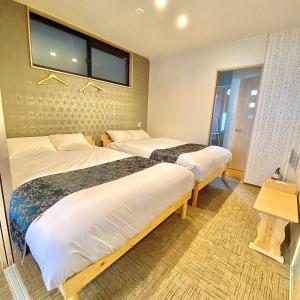 une chambre d'hôtel avec deux lits et une fenêtre dans l'établissement Guest House One More Heart at Kyoto Station South 5, à Kyoto