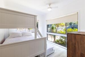 een slaapkamer met een stapelbed en een groot raam bij Galoola Hidden Gem, 2 97 Galoola Drive, Pet friendly, Rooftop outdoor area with spectacular views, Wi-Fi and air conditioning in Nelson Bay