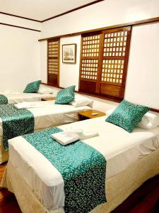 ein Hotelzimmer mit 3 Betten und blauen Kissen in der Unterkunft BALÉ in Malabañas