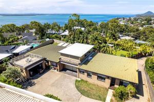 an aerial view of a house with the ocean in the background at Galoola Hidden Gem, 2 97 Galoola Drive, Pet friendly, Rooftop outdoor area with spectacular views, Wi-Fi and air conditioning in Nelson Bay