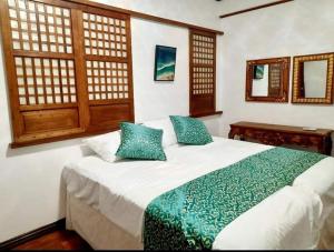 a bedroom with a large white bed with blue pillows at BALÉ in Malabañas