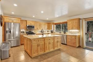 une cuisine avec des placards en bois et des appareils en acier inoxydable dans l'établissement 2147-Three Bears Inn home, à Big Bear Lake