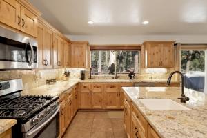 La cuisine est équipée de placards en bois et d'un four avec plaques de cuisson. dans l'établissement 2147-Three Bears Inn home, à Big Bear Lake