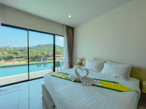 a bedroom with a large bed and a pool at Viva Montane Hotel Pattaya in Pattaya South