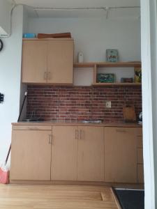 a kitchen with wooden cabinets and a brick wall at Jarrdin Apartments a Strategic and Comfy Room in the middle of Heart Bandung City in Bandung