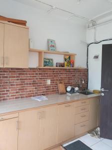 a kitchen with a brick wall and a counter at Jarrdin Apartments a Strategic and Comfy Room in the middle of Heart Bandung City in Bandung