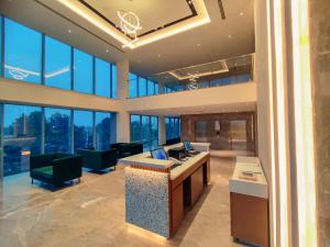 an office lobby with a desk and chairs and windows at Signature Hotels in Visakhapatnam