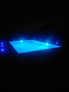SharīyahAl Ghadeer Maison Masfout的蓝色灯光的游泳池