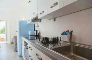 cocina con fregadero y fogones horno superior en Private Town Apartments by Mykonos Eight, en Mykonos ciudad