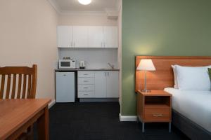 een hotelkamer met een bed en een keuken bij Leisure Inn Spires in Leura