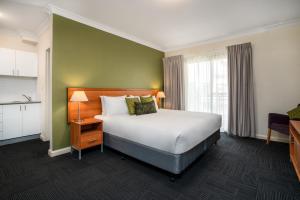 a hotel room with a bed and a window at Leisure Inn Spires in Leura