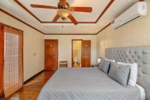 una camera da letto con un letto e un ventilatore a soffitto di Exclusive Full House near Beaches & Downtown a Roatán